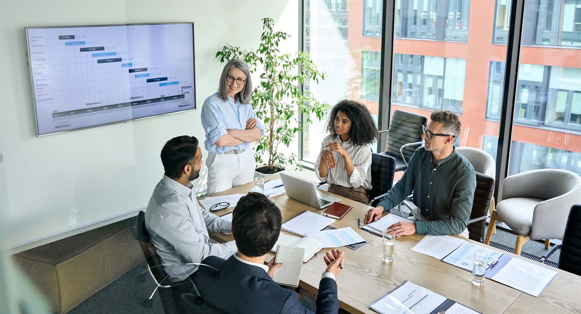 Channel leadership reviewing a program timeline in a conference room