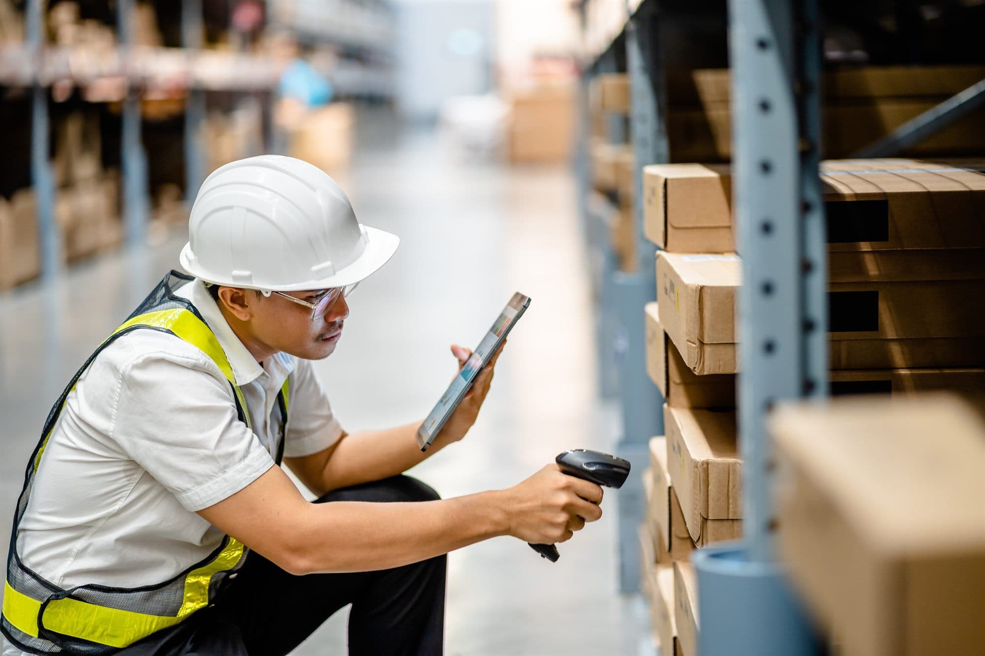 Warehouse operator scanning inventory with a tablet and barcode scanner