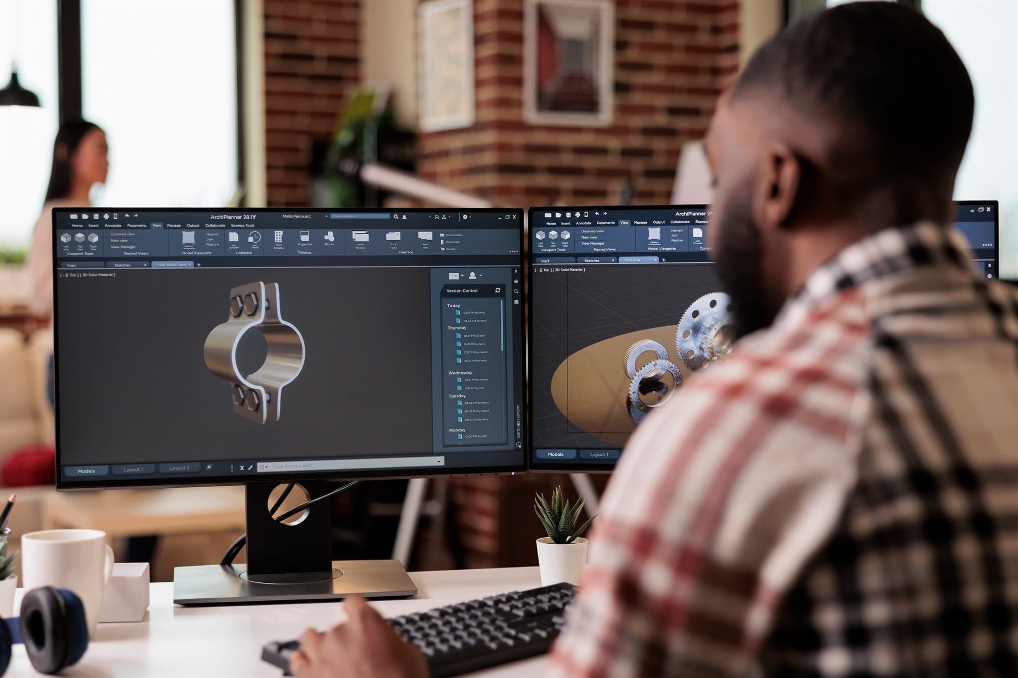 Engineer reviewing 3D CAD models of industrial parts on dual monitors